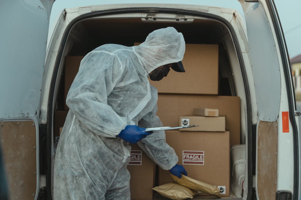 Person Wearing PPE Checking Parcels Inside a Delivery Van